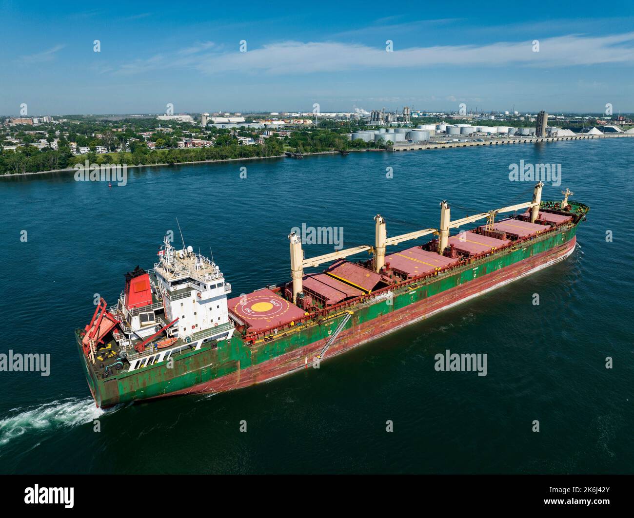 Aerial view of a fully loaded cargo ship leaving the Montreal Port and going downriver on the St.Lawrence River. Stock Photo