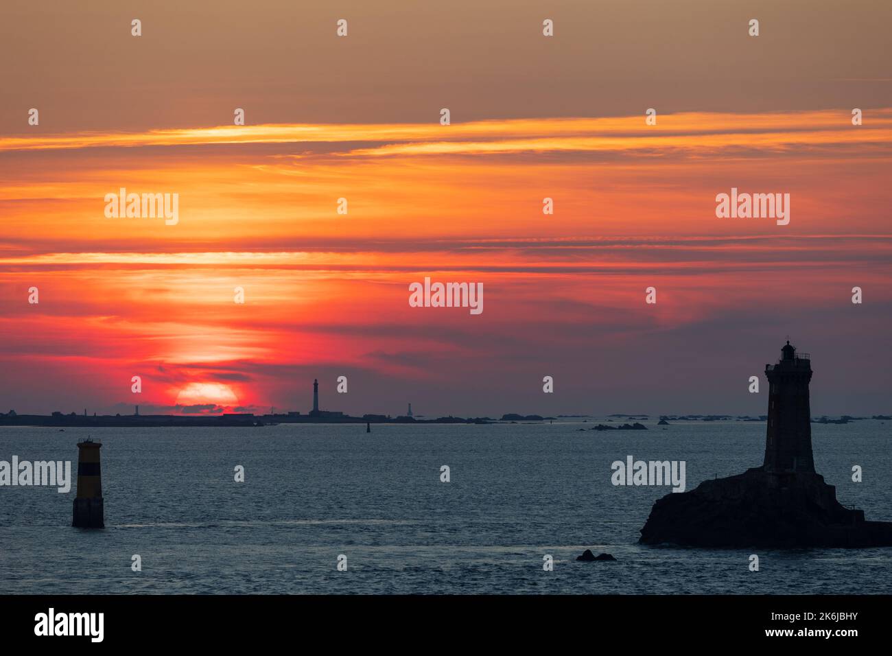 Warm colorful sunset over the Vieille lighthouse and the Sein island in Brittany, France Stock Photo