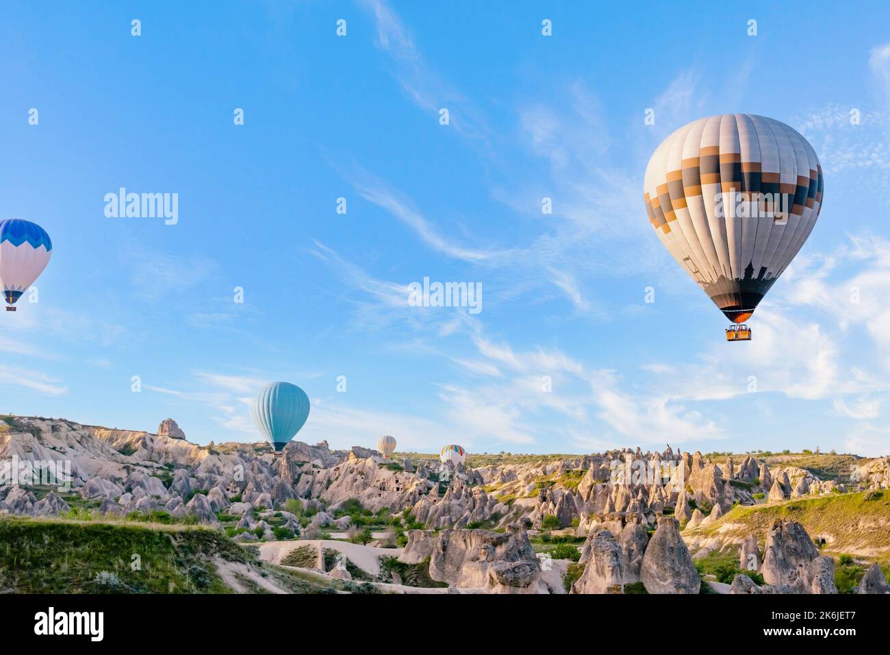 Colorful hot air balloons flying over rock landscape at Cappadocia ...