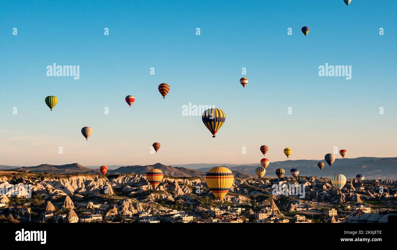 Colorful hot air balloons flying over rock landscape at Cappadocia ...