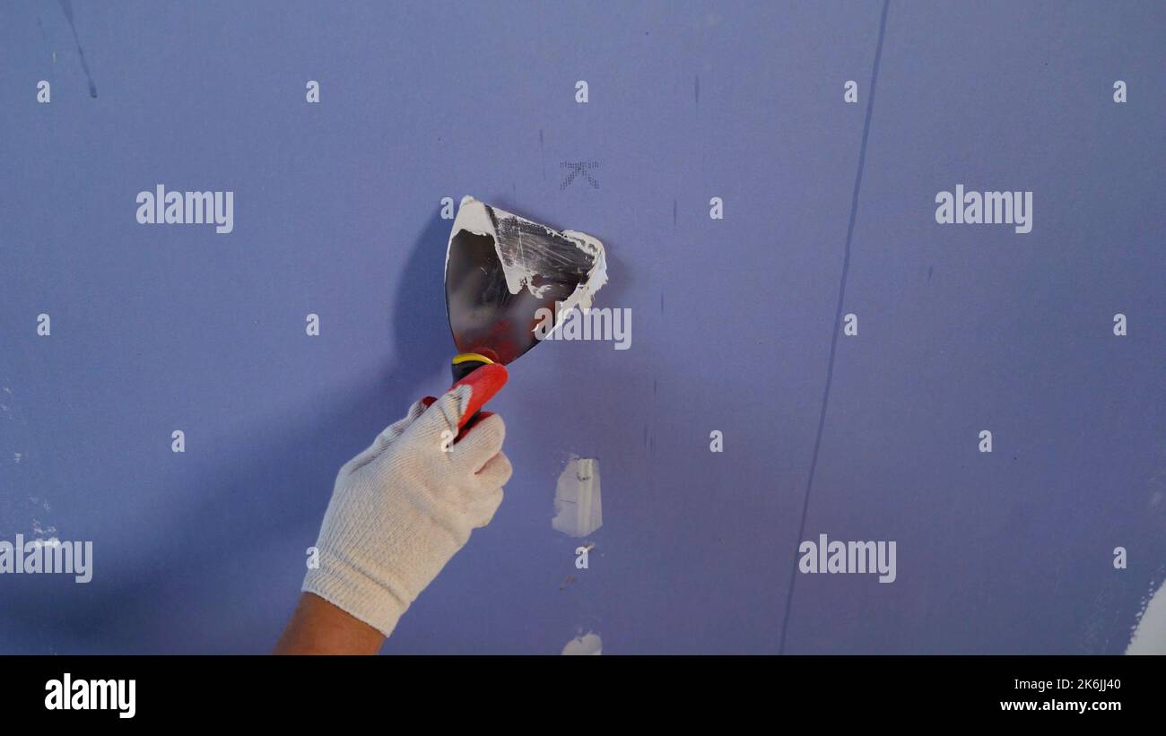 Apply putty to drywall. Applying putty to the gypsum plasterboards