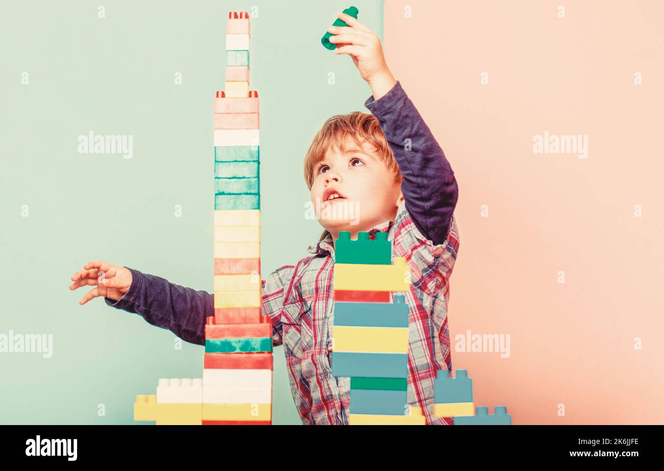 Little boy playing with lots of colorful plastic blocks constructor ...