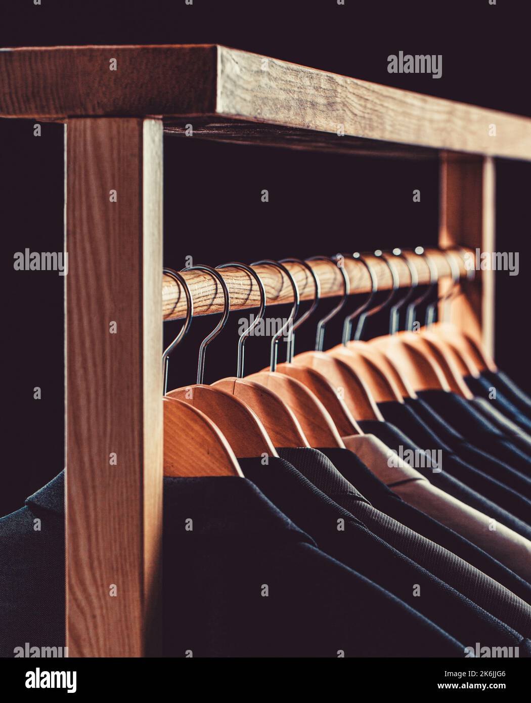 Mens suits in different colors hanging on hanger in a retail clothes