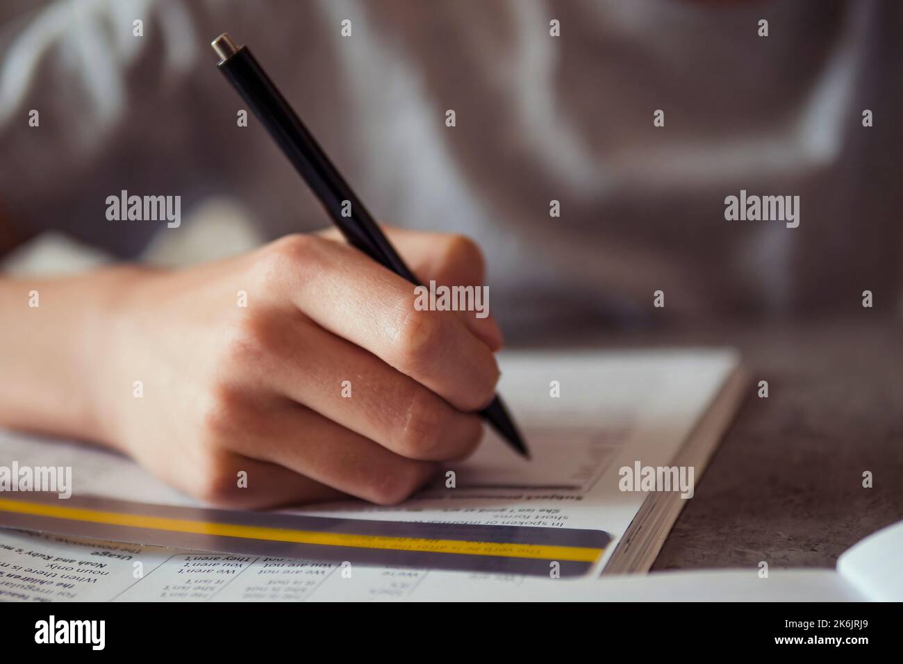 Kid affected by dyslexia doing homework, writing, reading notebook task ...