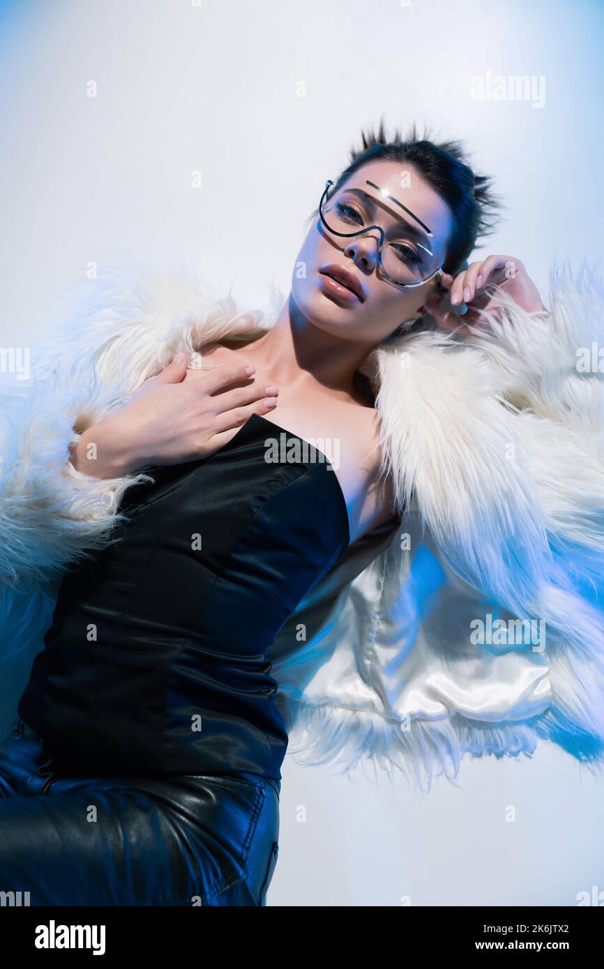 Top view of trendy young woman in sunglasses and faux fur jacket ...