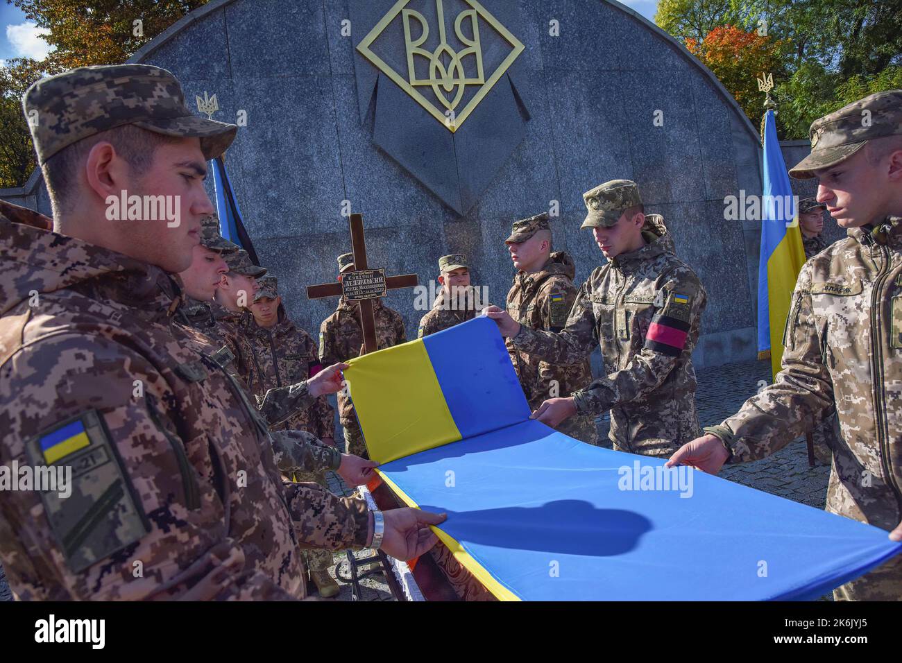 Ukrainian soldiers place the flag of Ukraine over the coffin of their comrade, who died during the funeral at the Lychakiv cemetery in Lviv. On February 24, Russia attacked Ukraine. the Russians are killing and torturing the civilian population, destroying residential buildings and critical infrastructure in Ukrainian cities. (Photo by Pavlo Palamarchuk / SOPA Images/Sipa USA) Stock Photo
