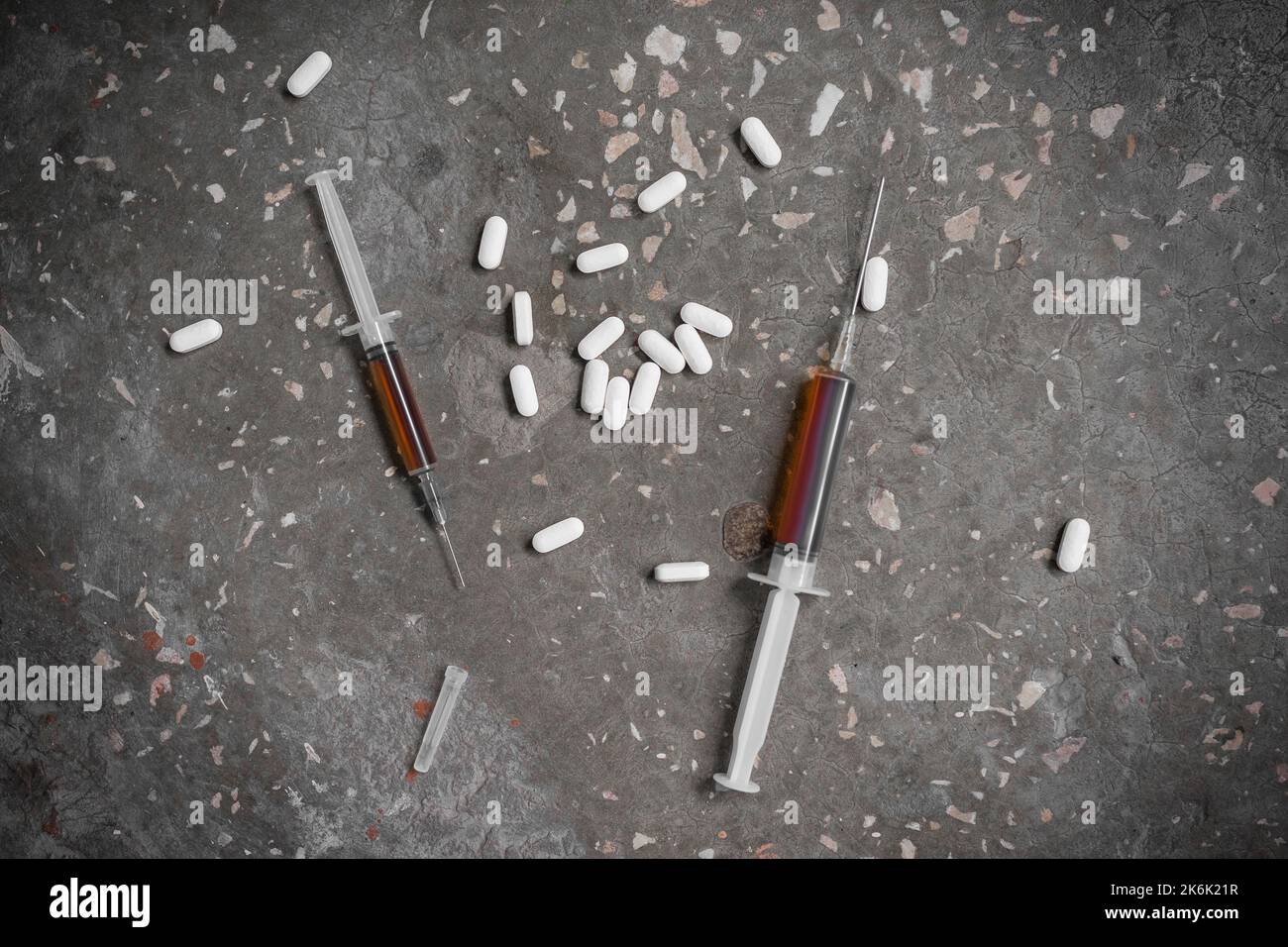 A closeup of a syringe and pills. The concept of drug abuse, overdose. View from above. Stock Photo