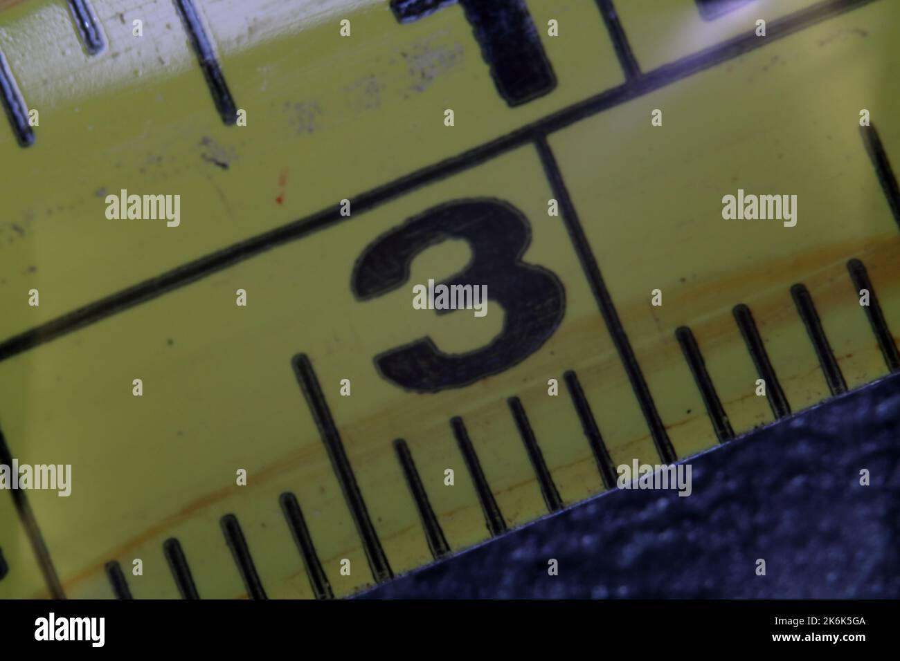 Close-up of the yellow measuring tape indicating the measure three. Number three. Stock Photo