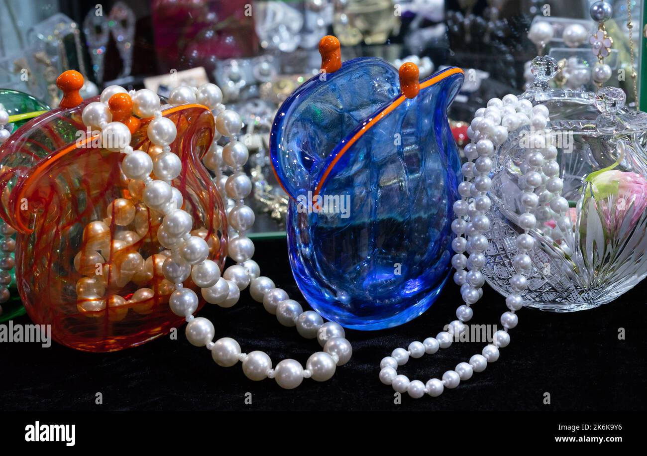 Beads of large pearls in glass vases in the shape of an old purse. Stock Photo