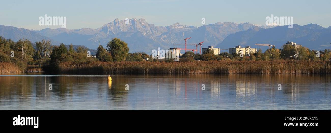 Houses in Wetzikon, shore of Lake Pfaeffikersee and mountain ranges. Stock Photo