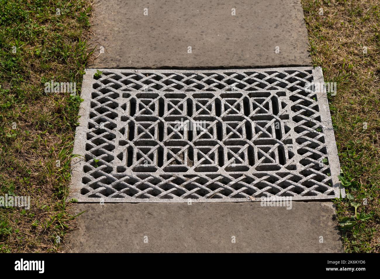 Iron gutter with grate cover of drainage system on pedestrian walkway