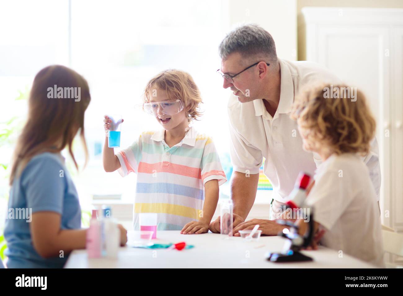 School science class. Students at chemistry lesson. Kids watch chemical reaction. Teacher and