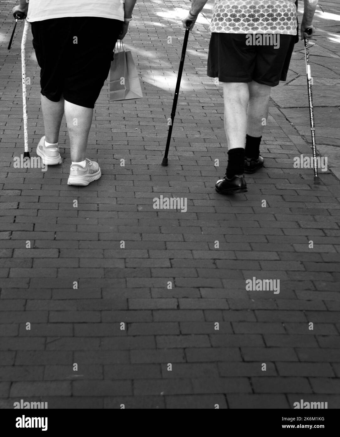 Two elderly women with walking canes walk along a sidewalk in Santa Fe, New Mexico. Stock Photo