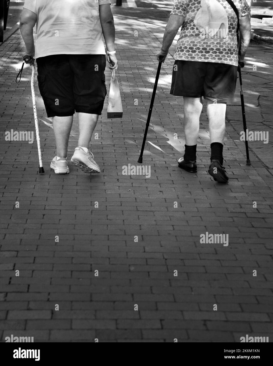 Two elderly women with walking canes walk along a sidewalk in Santa Fe, New Mexico. Stock Photo