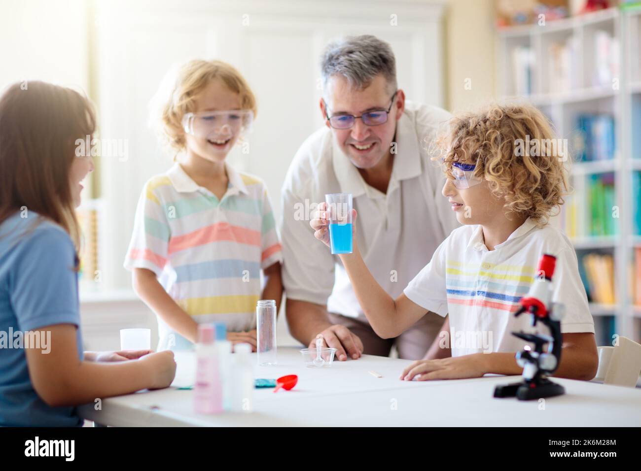 School science class. Students at chemistry lesson. Kids watch chemical reaction. Teacher and