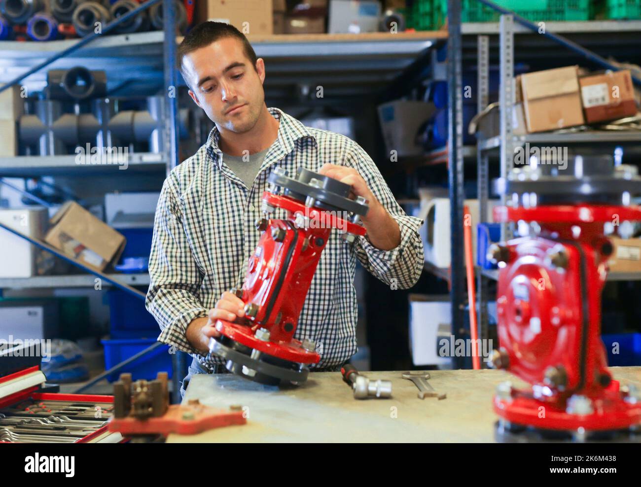 Man assembling plumbing fixture in workshop Stock Photo