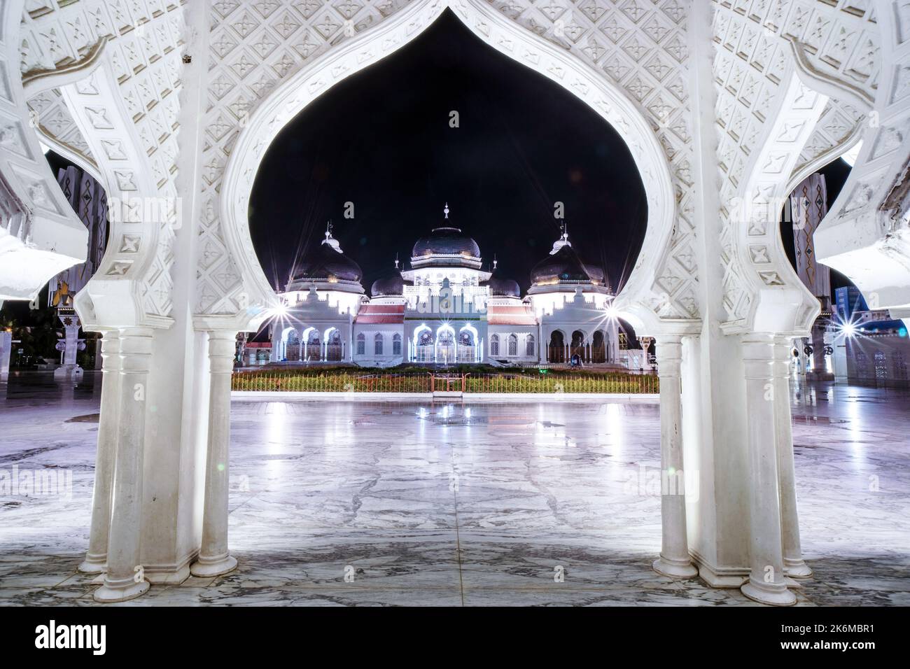 Aceh, Indonesia. October 14, 2022. Baiturrahman Grand Mosque, Banda Aceh, framed by the mosque gate, at midnight Stock Photo