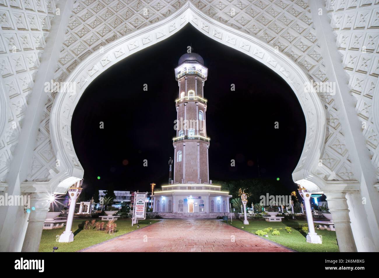 Aceh, Indonesia. October 14, 2022. Baiturrahman Grand Mosque minaret, Banda Aceh, framed by the mosque gate, at midnight Stock Photo