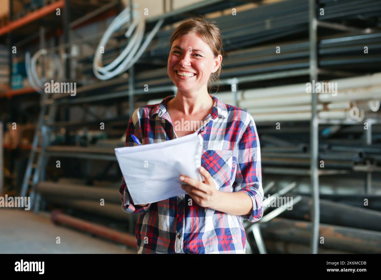 Joyful woman inspecting warehouse Stock Photo