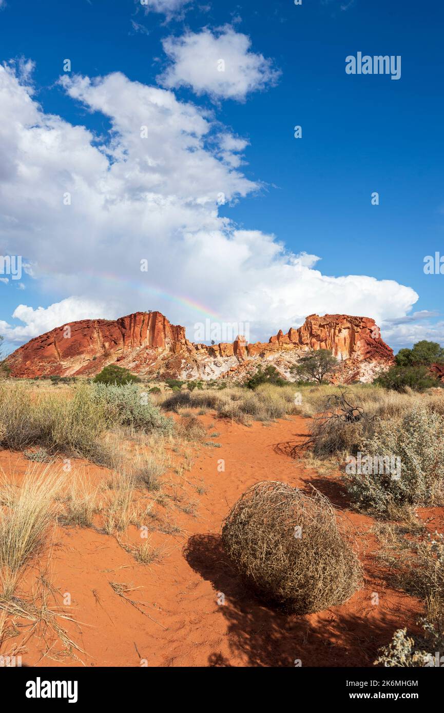 Vertical scenic view of Rainbow Valley with a rainbow in the clouds, a popular tourist destination, Northern Territory, NT, Australia Stock Photo