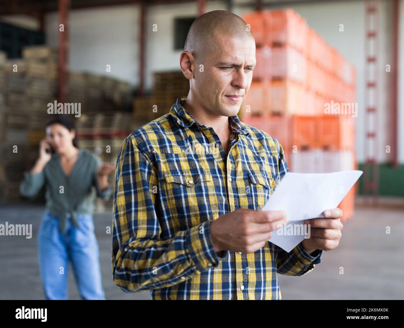 Confident male manager with documents inside large warehouse Stock Photo