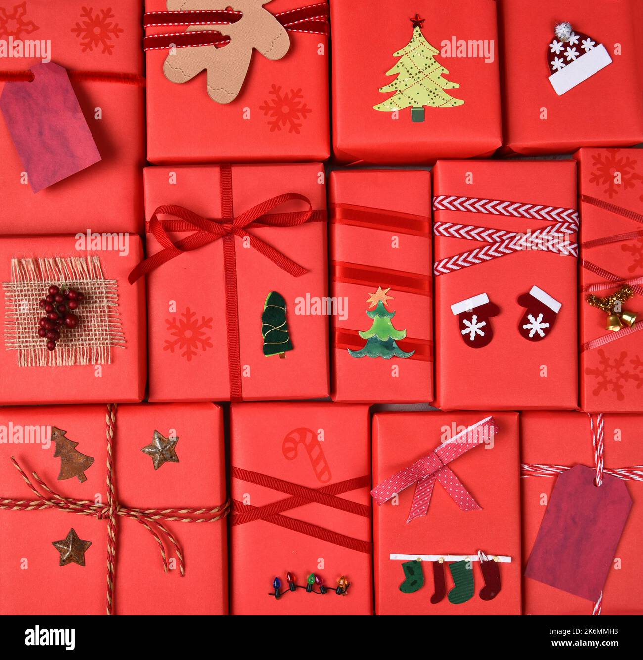 Christmas Presents. Closeup of gifts wrapped in red paper with ribbons and decorations. Square format filling the frame. Stock Photo