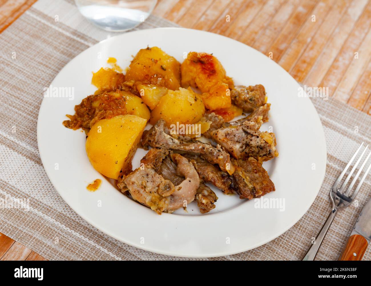 Braised rabbit served with potato garnish Stock Photo