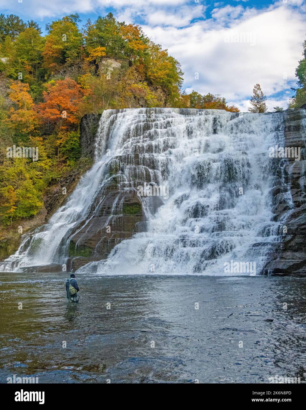 Ithaca Falls with fisherman wading in current New York State with