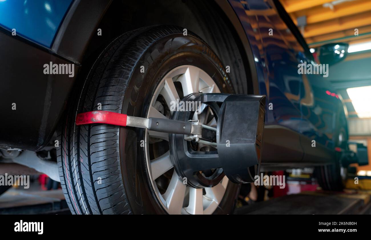 Wheel alignment equipment grip the tire of car wheel in car repair shop