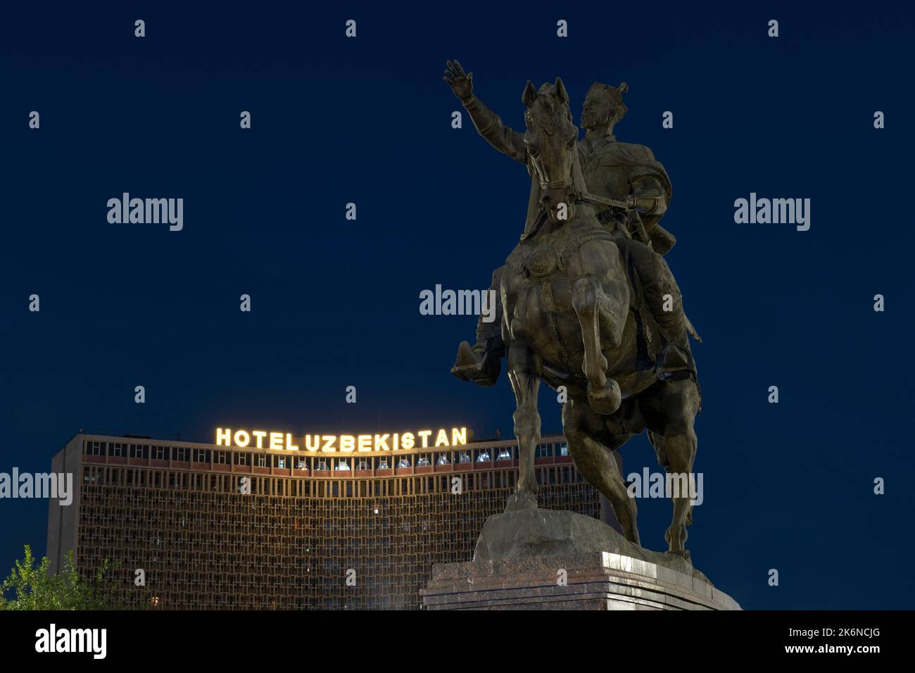 TASHKENT, UZBEKISTAN - SEPTEMBER 15, 2022: Monument to Amir Temur (Tamerlane) against the backdrop of the Uzbekistan Hotel in the late evening Stock Photo