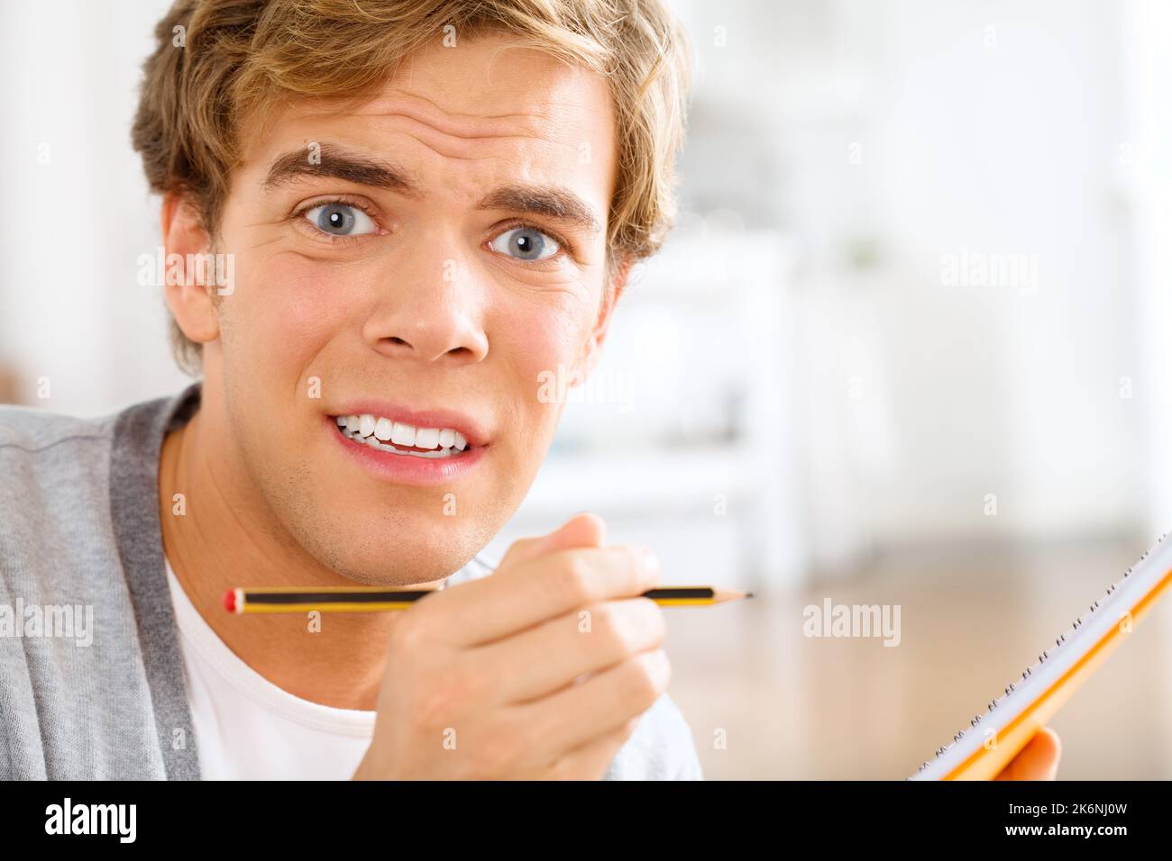 I dont think Ill remember this. a young man looking stressed out while making notes. Stock Photo