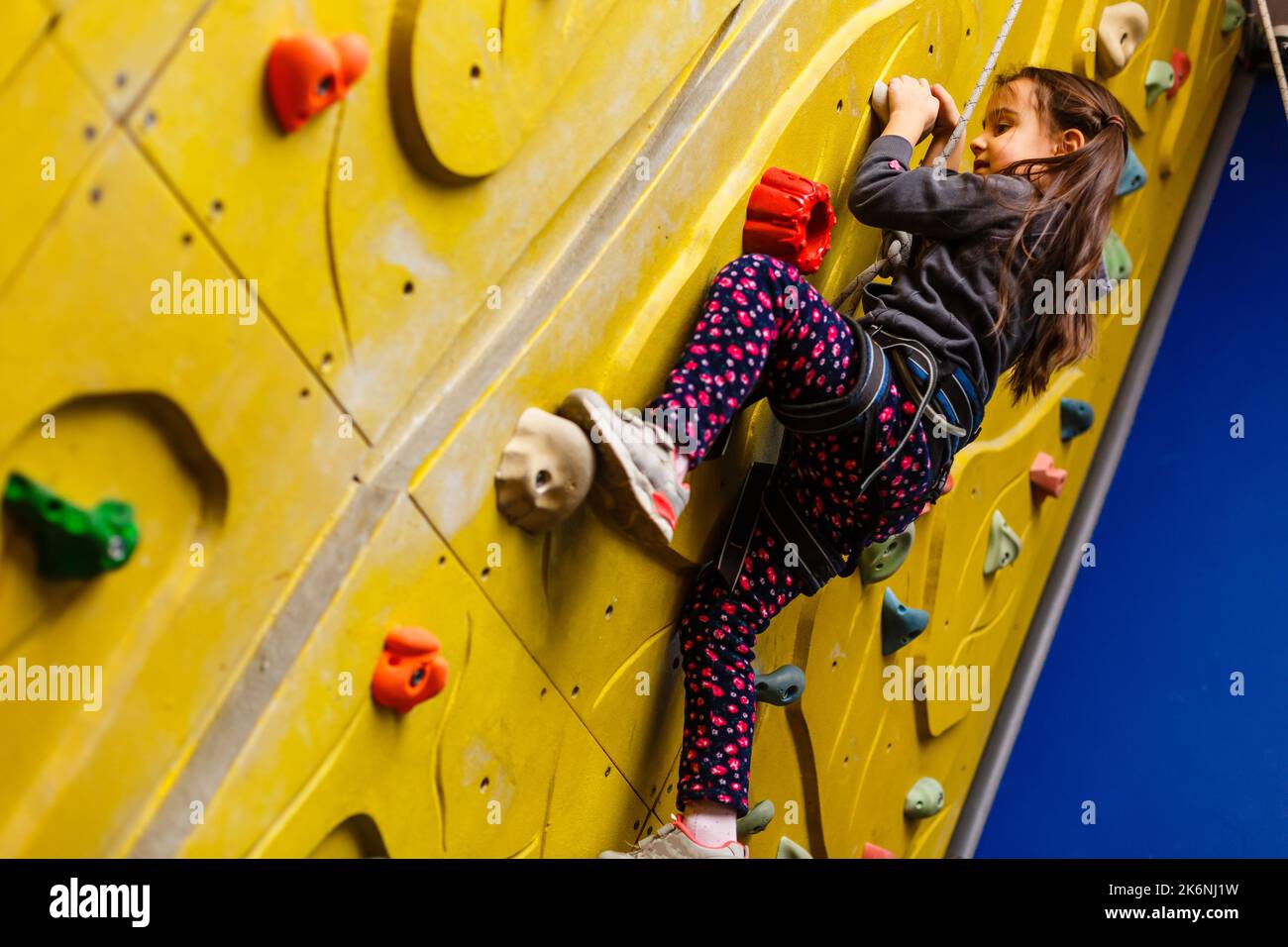 little girl climbing a rock wall indoor Stock Photo Alamy