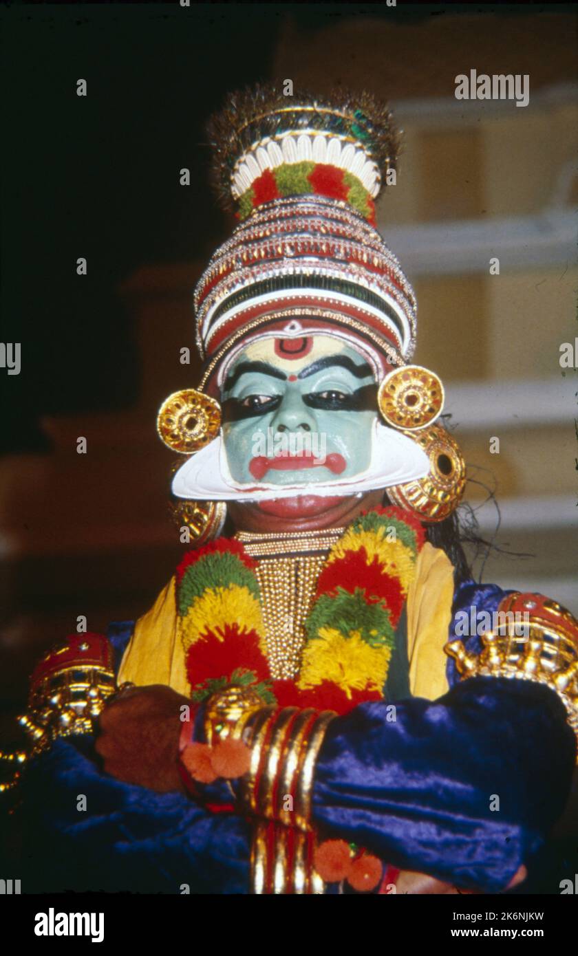 Kathakali:- Indian Classical Dance from Kerala is based on Ramayana, Mahabharata and Stories from Shaiva Literature. Performed outdoors in an all night function, voices chant the stories as mimed by dancers. Traditionally Kathakali is performed by men and young boys, who play the parts of both males and females. Faces are made up to look like Painted Masks, The costumes consist of full skirt, heavy jacket, numerous garlands and neckless and towering headdress. Stock Photo