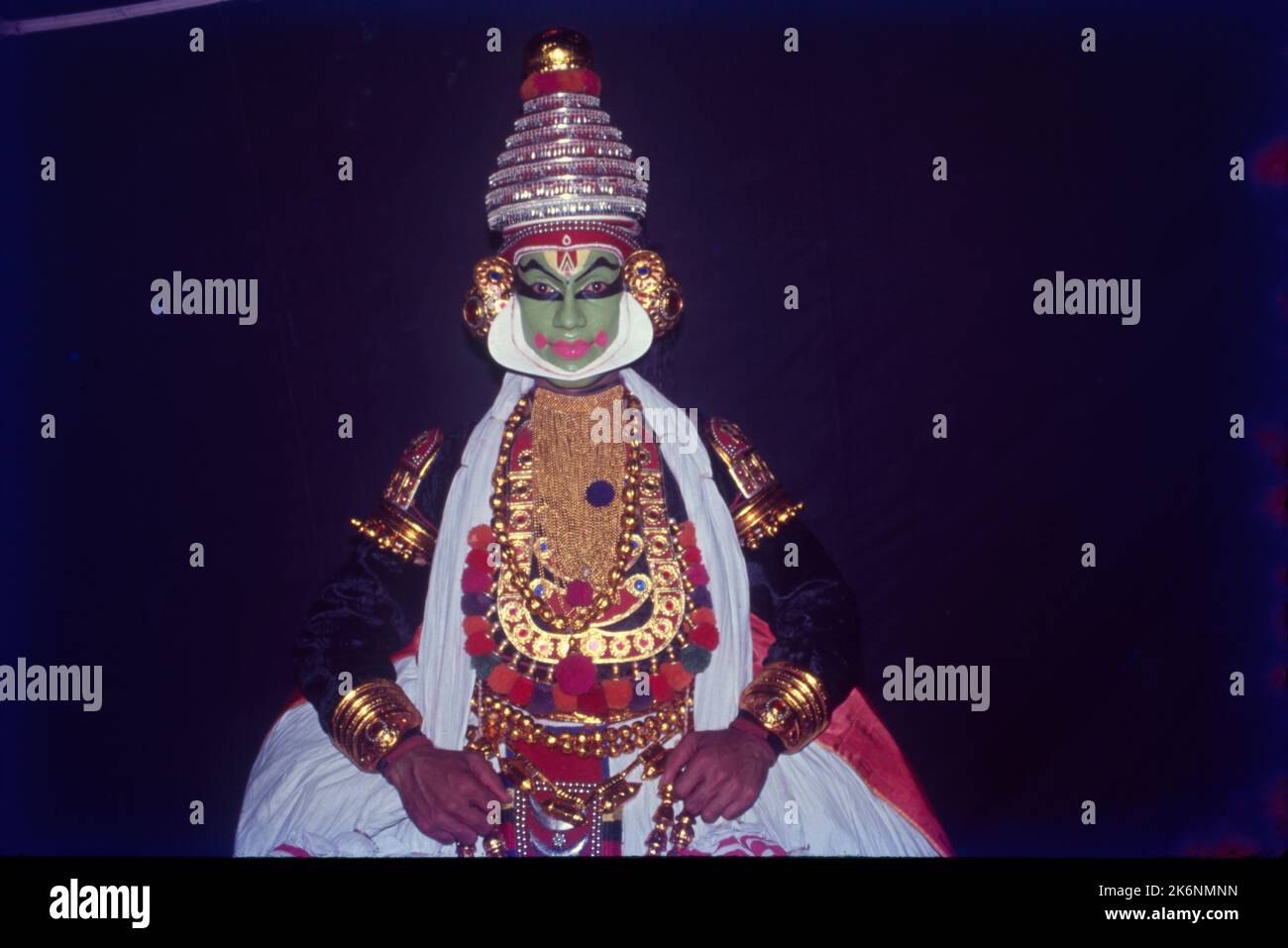 Kathakali:- Indian Classical Dance from Kerala is based on Ramayana, Mahabharata and Stories from Shaiva Literature. Performed outdoors in an all night function, voices chant the stories as mimed by dancers. Traditionally Kathakali is performed by men and young boys, who play the parts of both males and females. Faces are made up to look like Painted Masks, The costumes consist of full skirt, heavy jacket, numerous garlands and neckless and towering headdress. Stock Photo