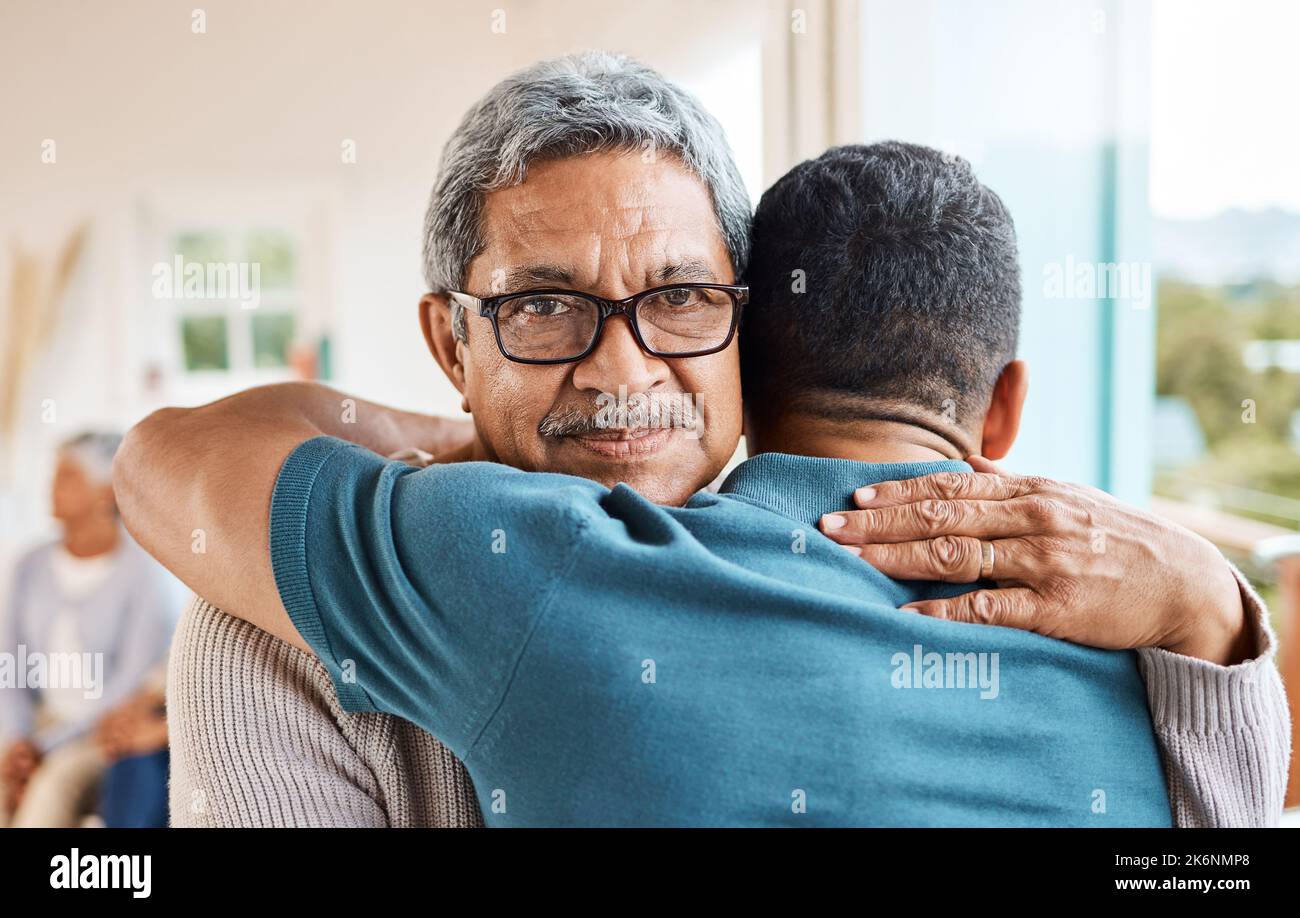 Hes never too old for a hug. a father and son hugging at home Stock