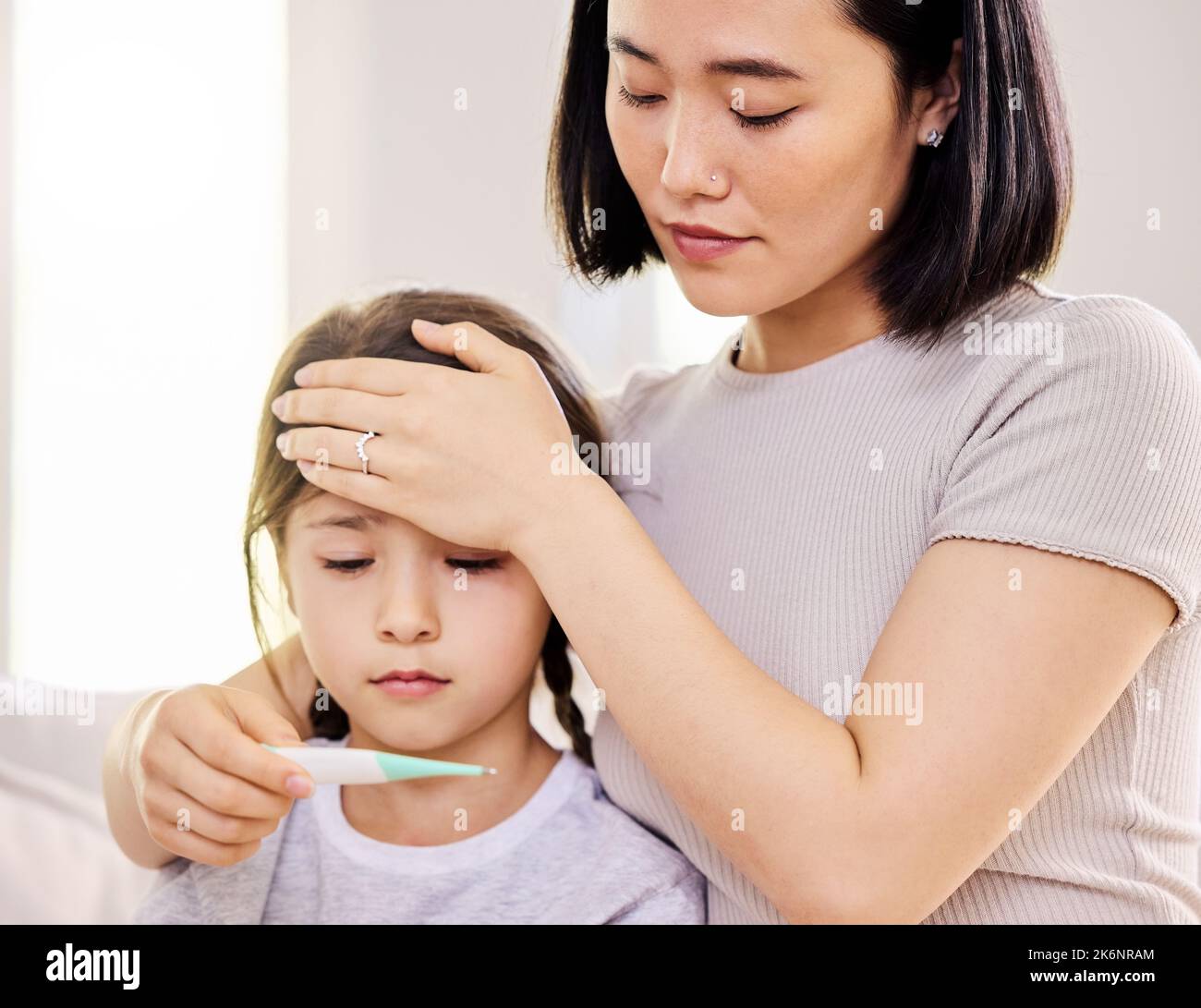 I hope you dont have a fever. a woman checking her sick childs