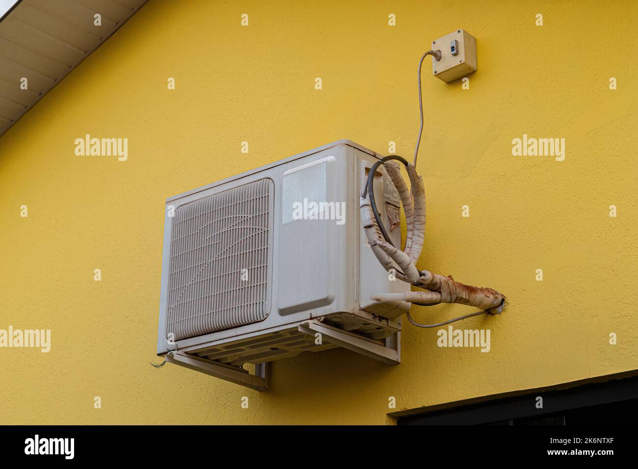 air conditioner condenser installed on the exterior wall of a house