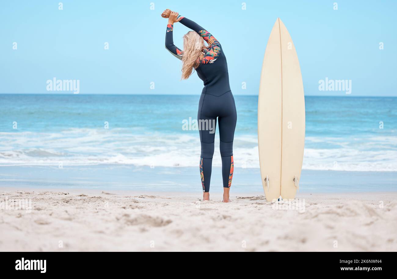 Surfing, stretching and woman surfer on beach standing by surfboard