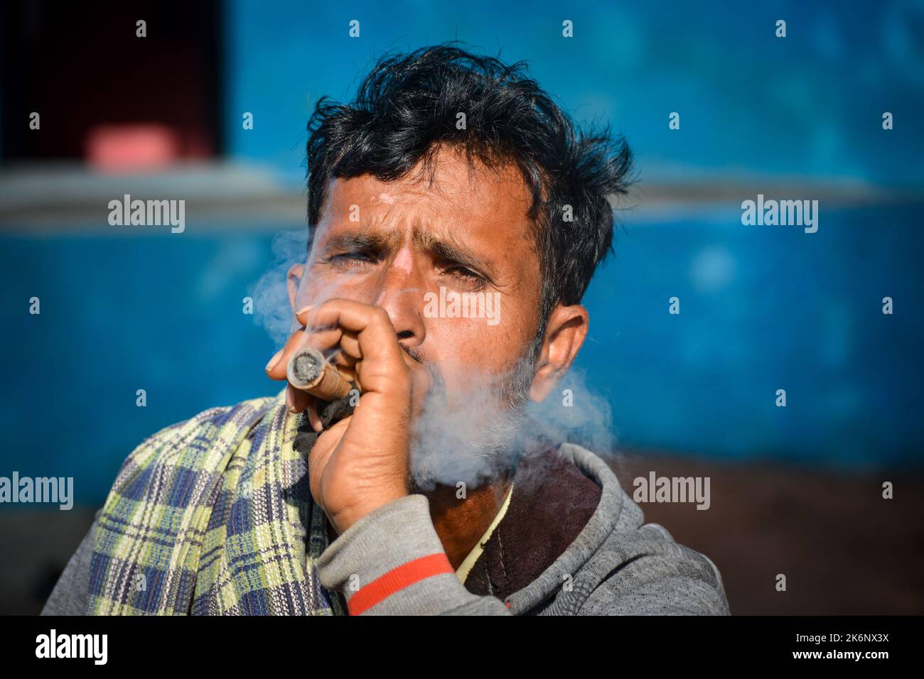 TIKAMGARH, MADHYA PRADESH, INDIA - JULY 12, 2022: Indian rural man smoking chilam. Stock Photo