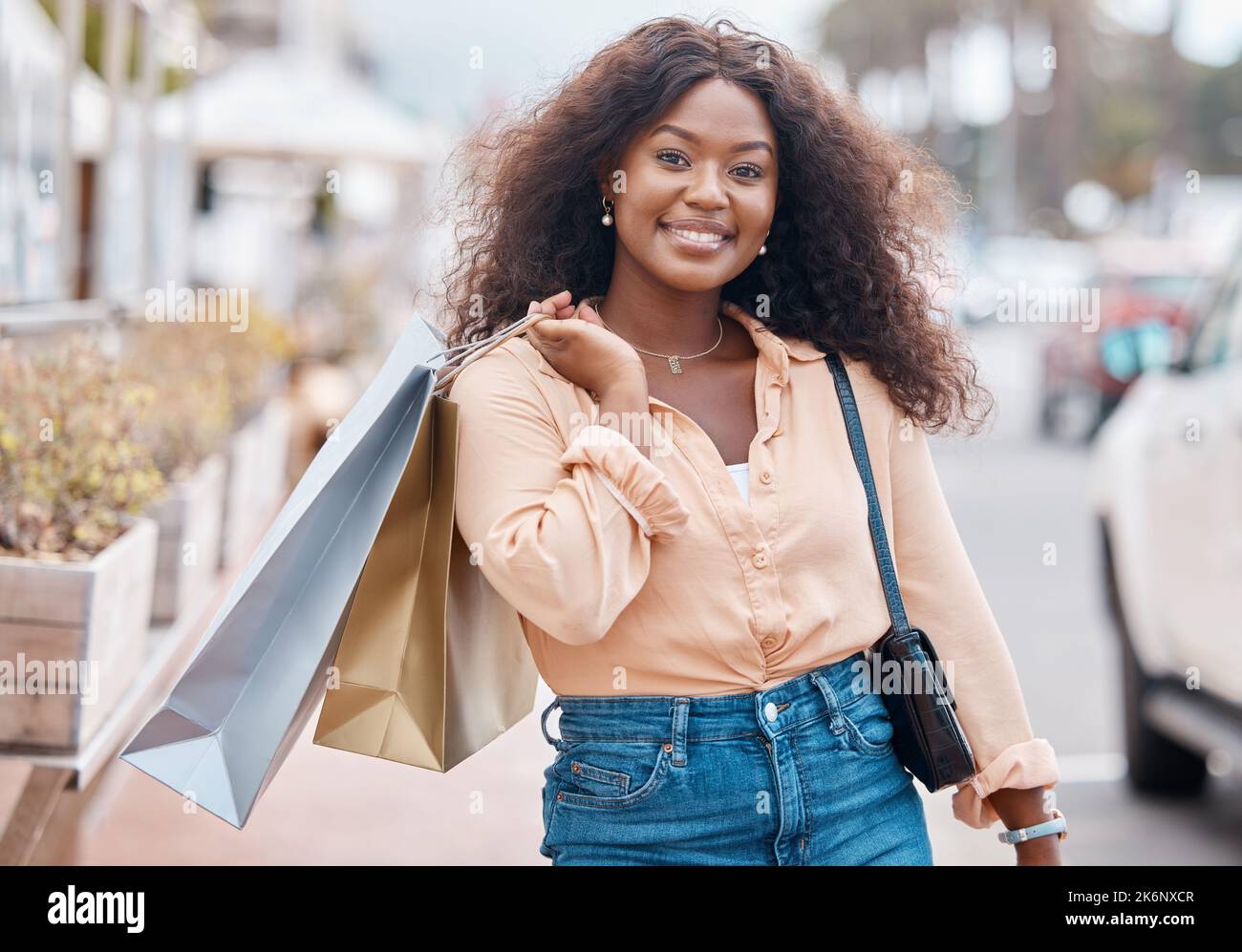 Black woman, shopping and bags with smile in the city for sale, discount and urban outdoors. Portrait of happy African American female shopper holding Stock Photo