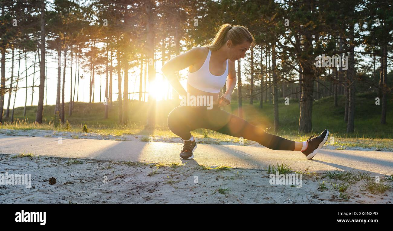 Young female workout before fitness training session at beach. Healthy