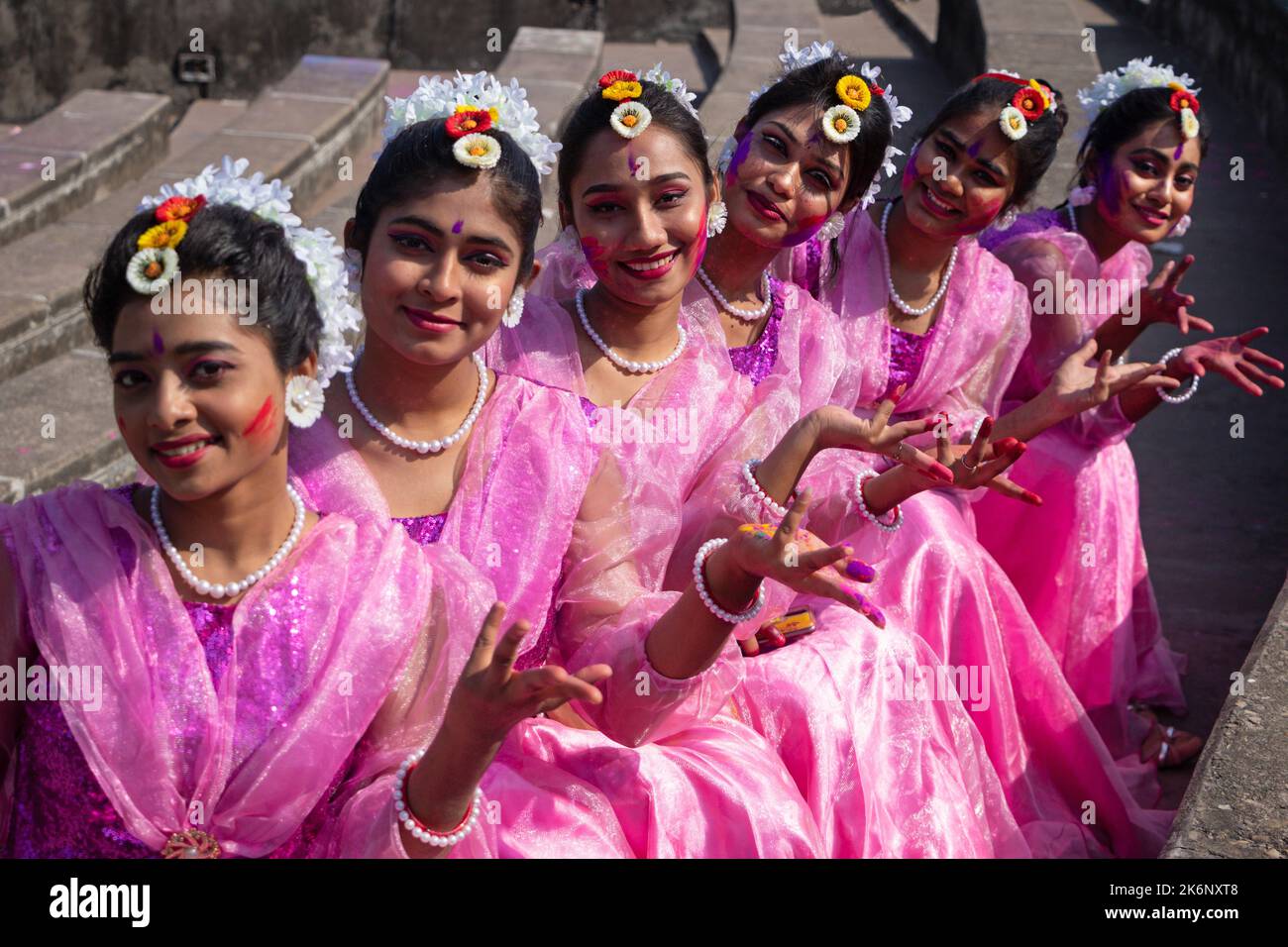 Women wear traditional dresses with floral ornaments and perform during
