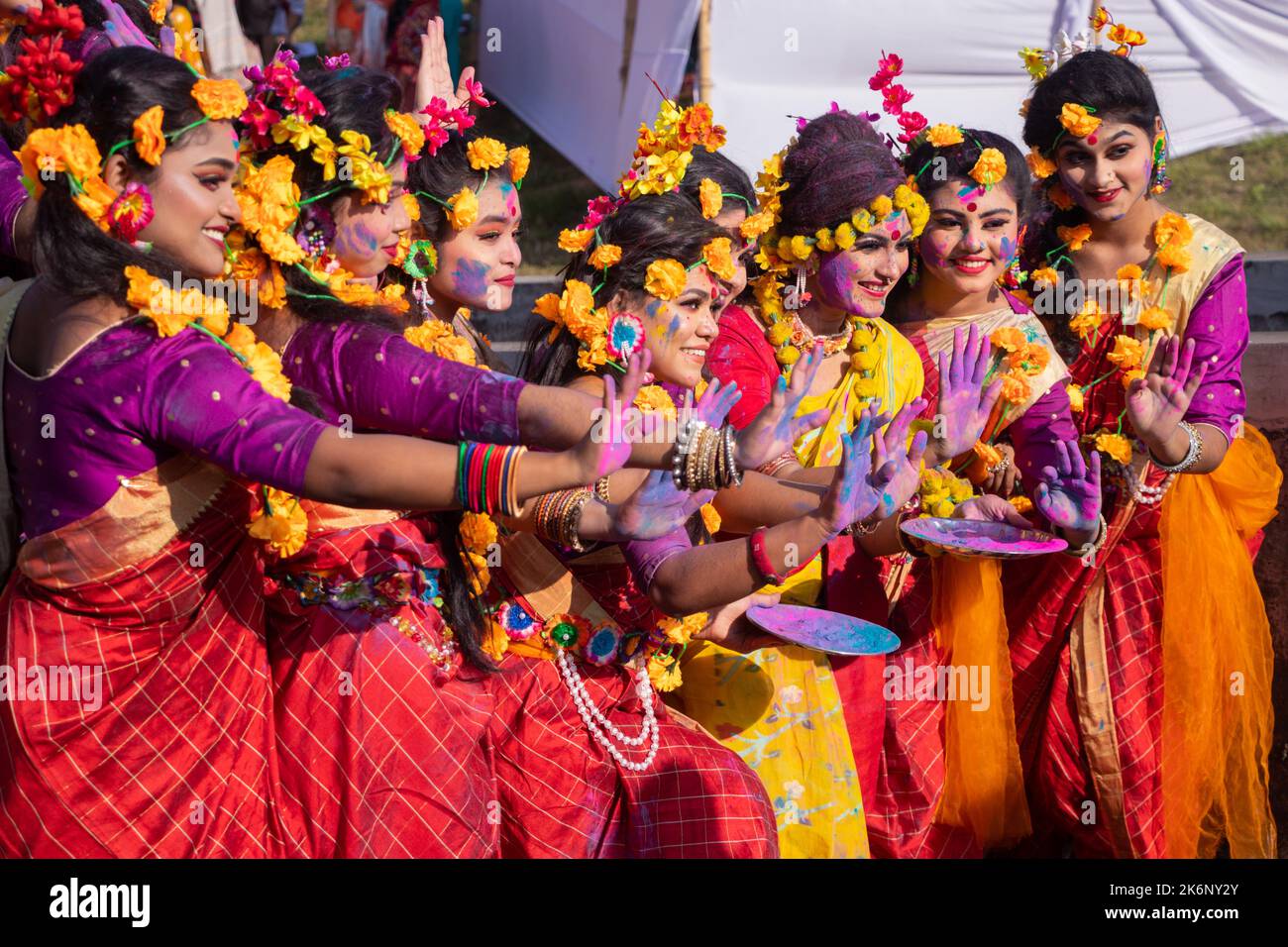 Women wear traditional dresses with floral ornaments and perform during