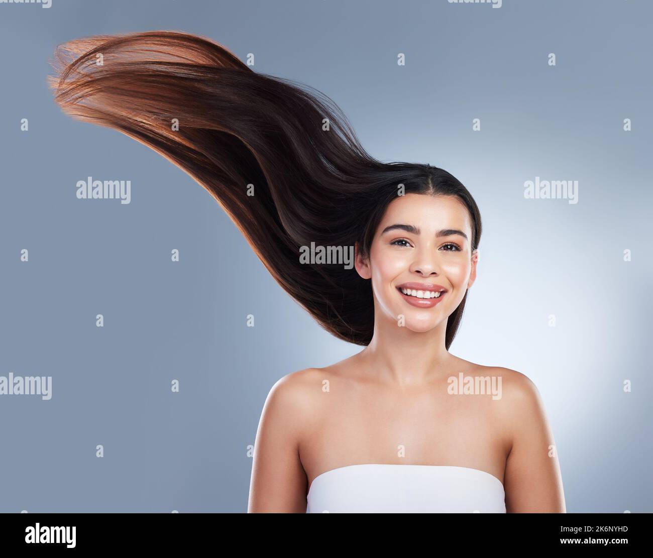 Portrait of woman with shiny smooth long hair. Young brunette woman with beautiful hair. Young girl with long brown hair flying in the wind against a Stock Photo