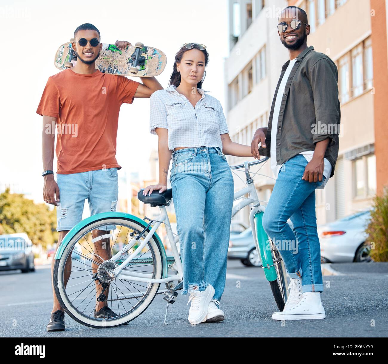 Fashion, Gen Z and skater friends portrait in road for hangout in Los Angeles neighbourhood. Skateboard, bike and diverse friendship with trendy Stock Photo