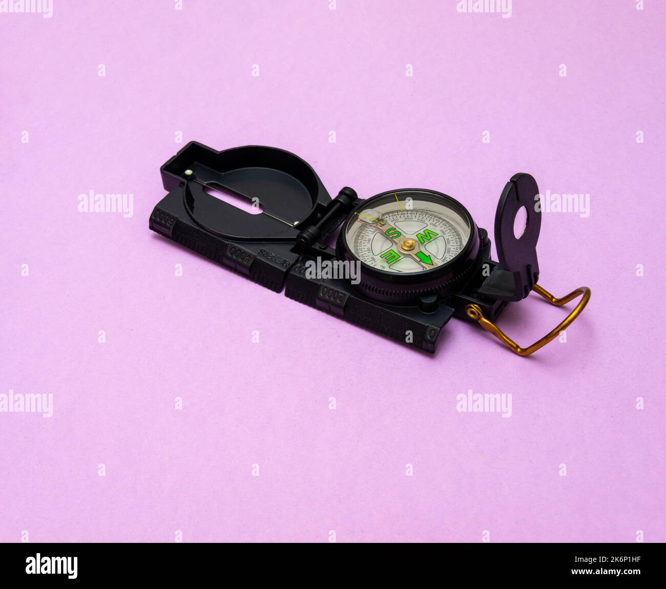 compass on pink background concept of adventure holidays