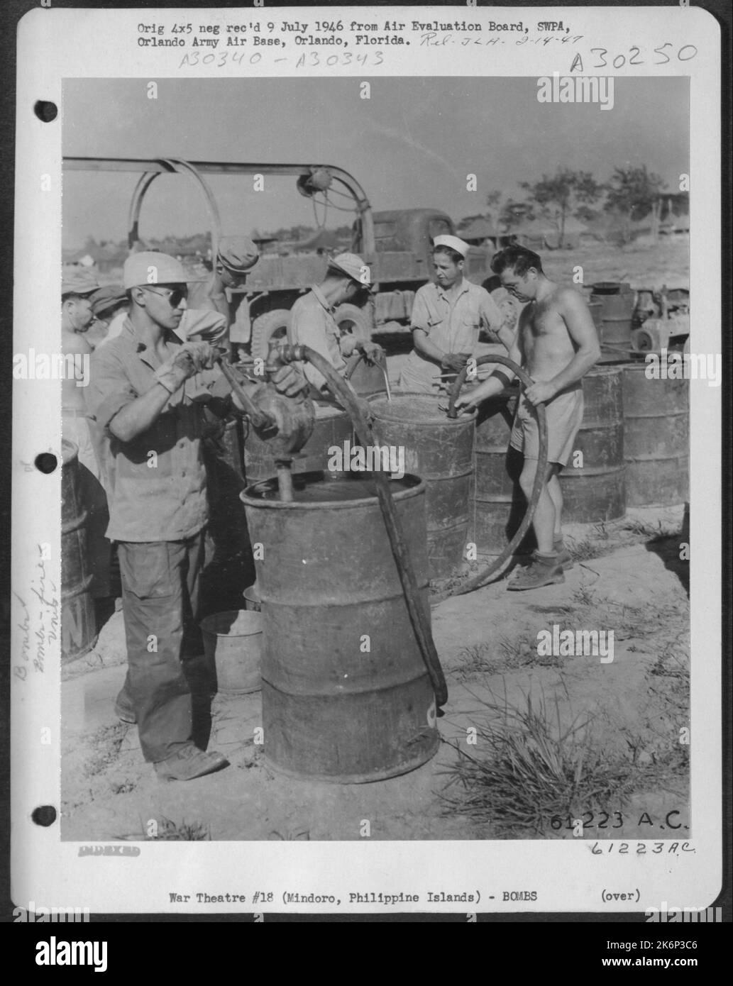 AAF Personnel mixing Napalm solution in 55 gallon drums. 894th Chemical Company, 3rd Bomb Group. Elmore Field, Mindoro, Philippine Islands. 10 April 1945. Stock Photo