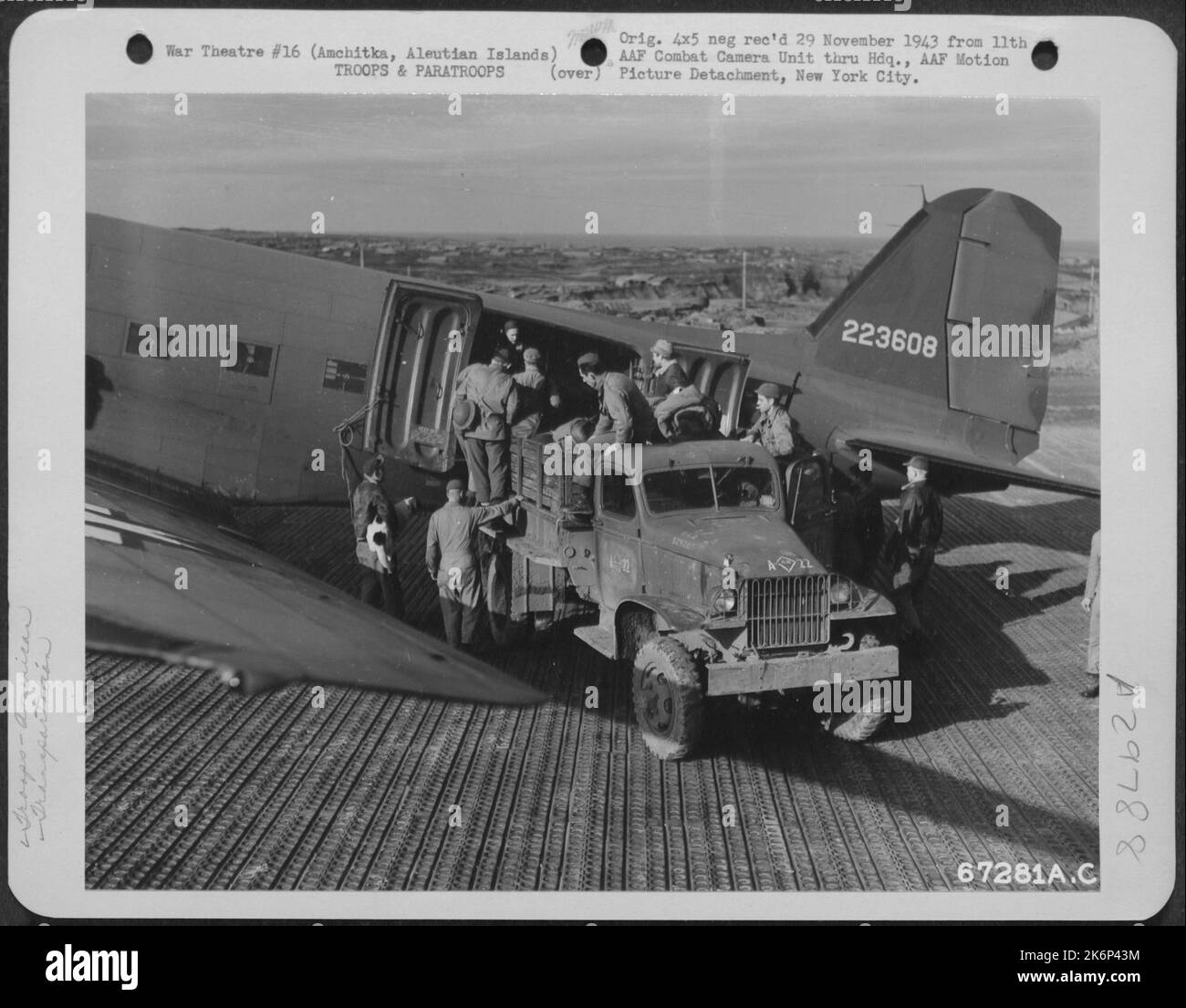 Troops, carrying rifles and bed rolls, board a transport plane at Amchitka, Aleutian Islands. 10 October 1943. Stock Photo