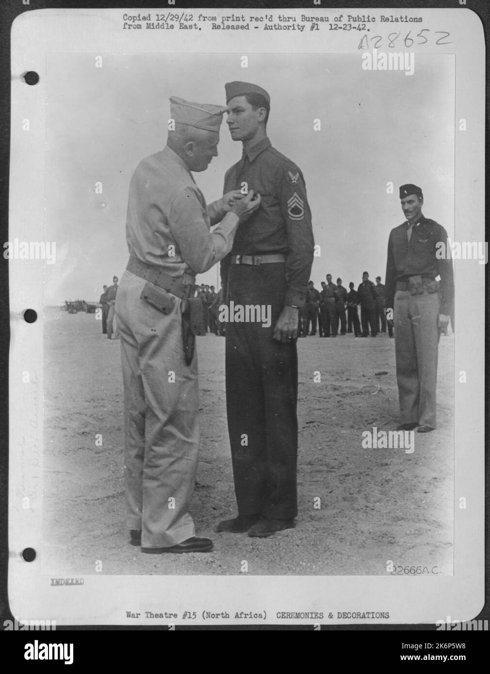 Cited for gallantry in action while acting as aerial gunner, T/Sgt. Marvin L. Breeding was presented the Order of the Purple Heart for wounds sustained while participating in combat with enemy aircraft, and also the Silver Star for remaining at his Stock Photo
