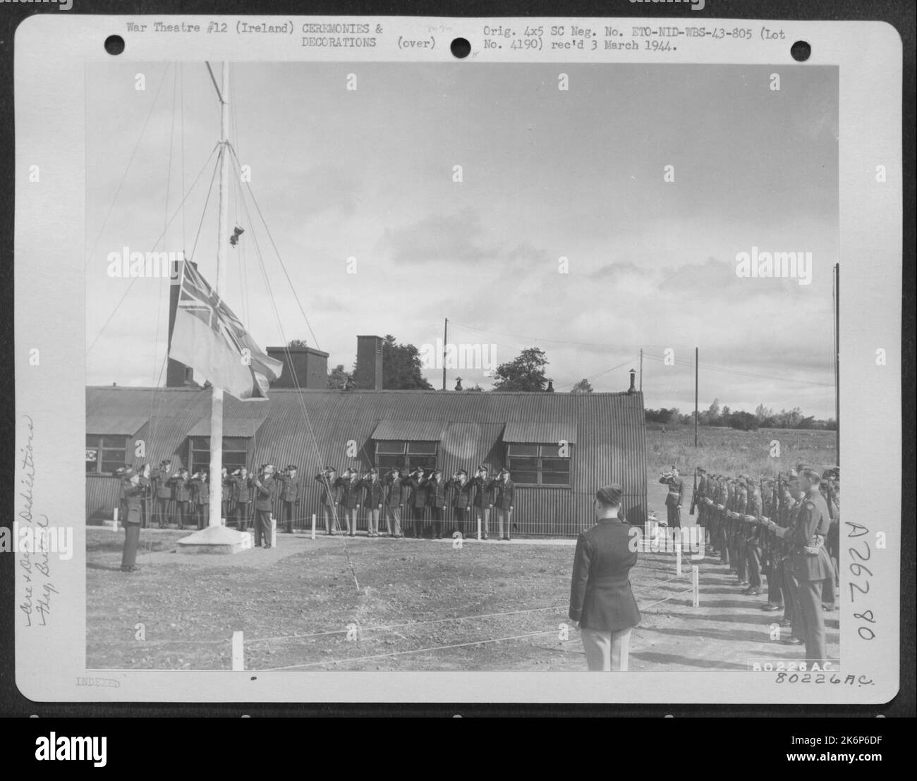 U.S. Army Air Force and Royal Air Force personnel salute the Union Jack as it is lowered during ceremonies turning over a former British airfield at Toome, Northern Ireland to the U.S. Army Air Force. 26 July 1943. Stock Photo